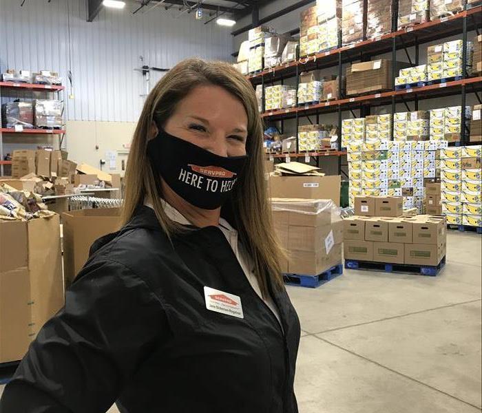 female employee with here to help mask standing in warehouse